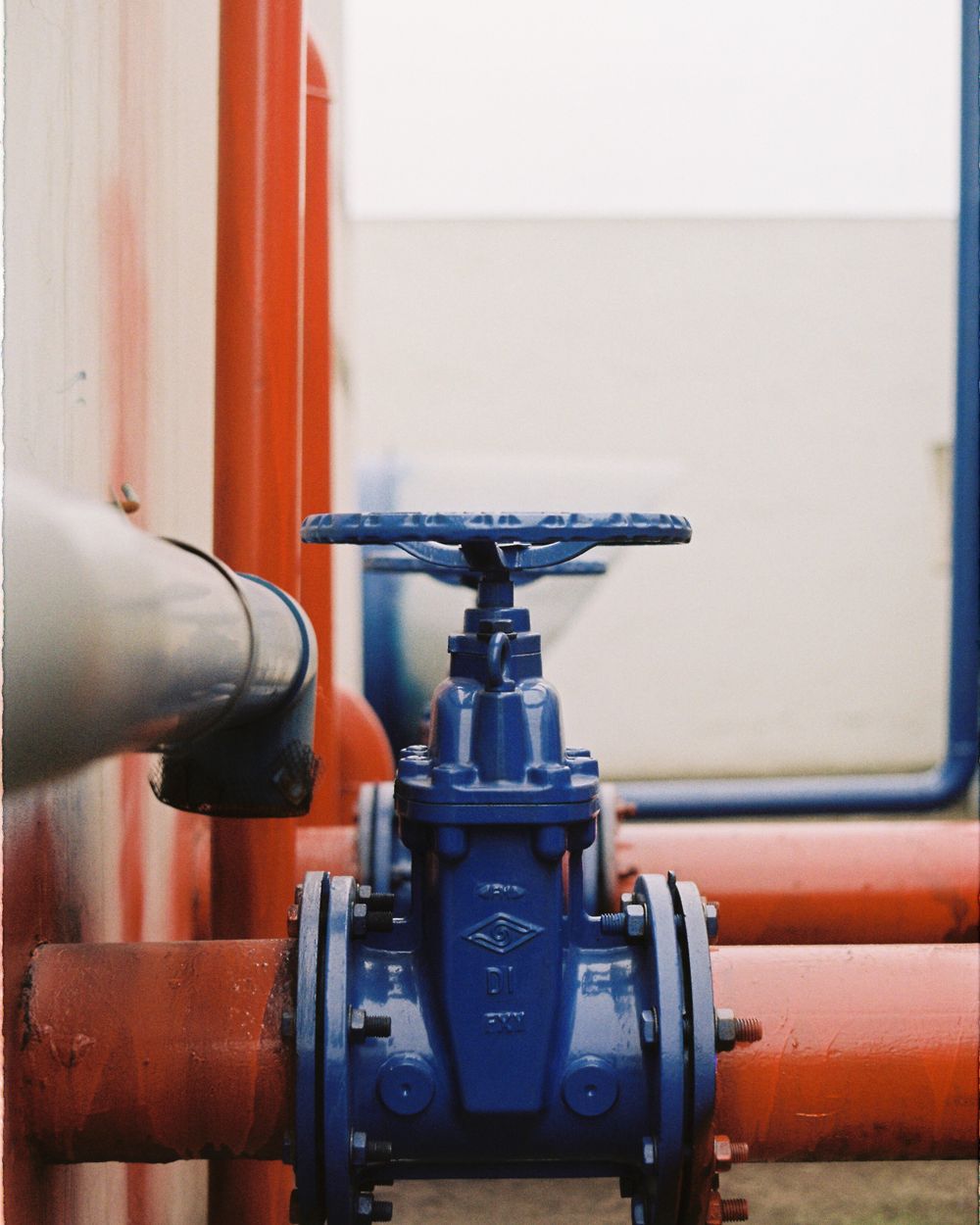 Blue gate valve fitted on a red water supply line
